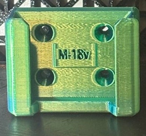 A compact and durable battery holder designed specifically for Milwaukee M18 batteries, featuring a vibrant fluorescent silk green color. The holder is crafted from a resilient material, providing a secure storage solution for your M18 batteries.