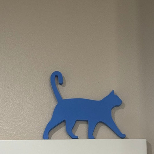 A unique and eye-catching door topper featuring a running Amur leopard silhouette, crafted in a gold color and displayed above a white door frame against a white background. This decorative piece is made in the USA.