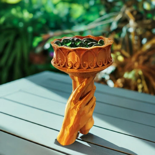 Liberty Torch Succulent Planter with a vibrant green plant, placed on an outdoor table, showcasing detailed design and rich colors.
